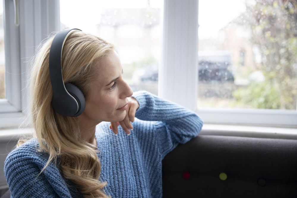 Nő fejhallgatóval figyelmesen zenét hallgat